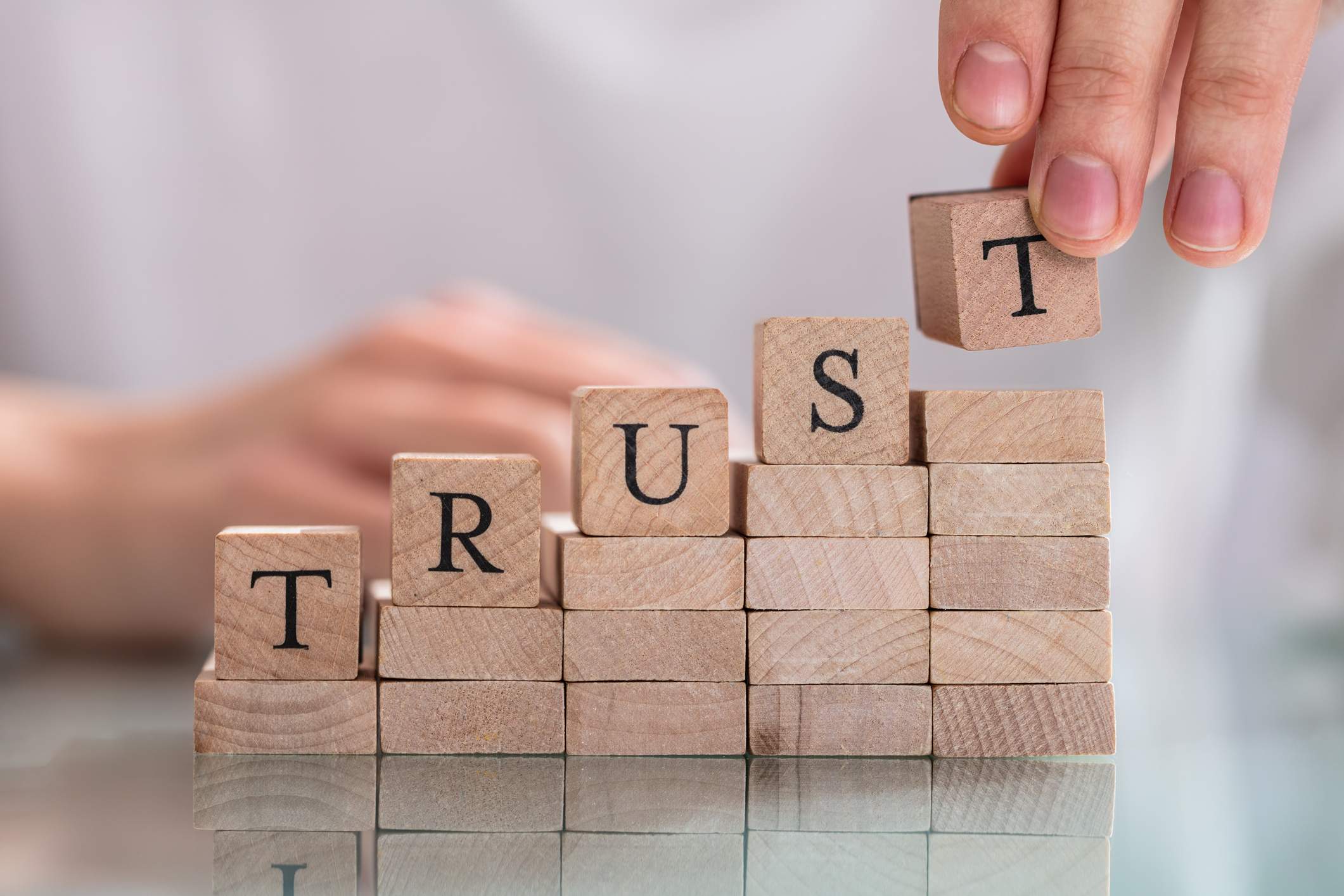 Woman’s Hand Placing Last Alphabet Of Word Trust