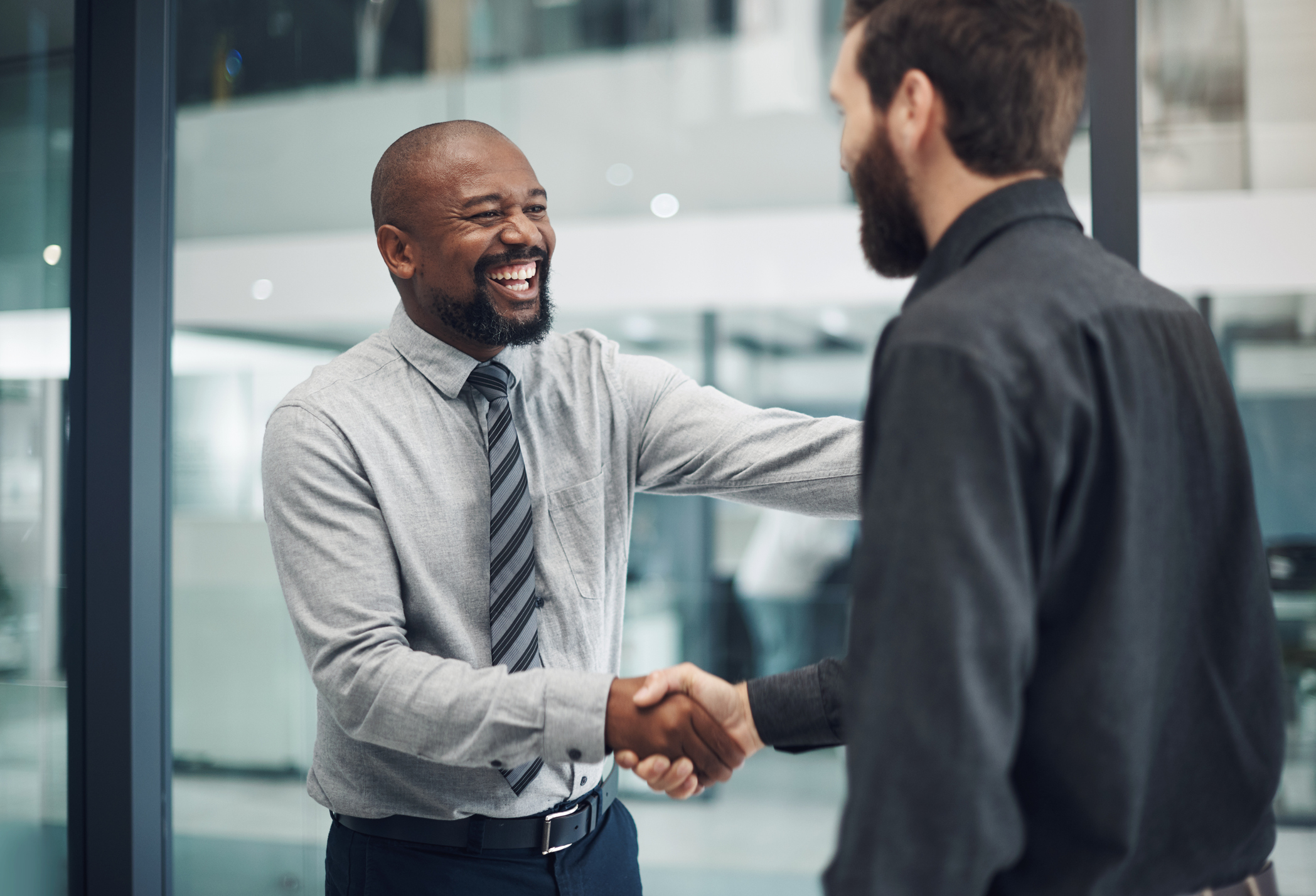 Shot of a mature businessman shaking hands with a colleague in a modern office