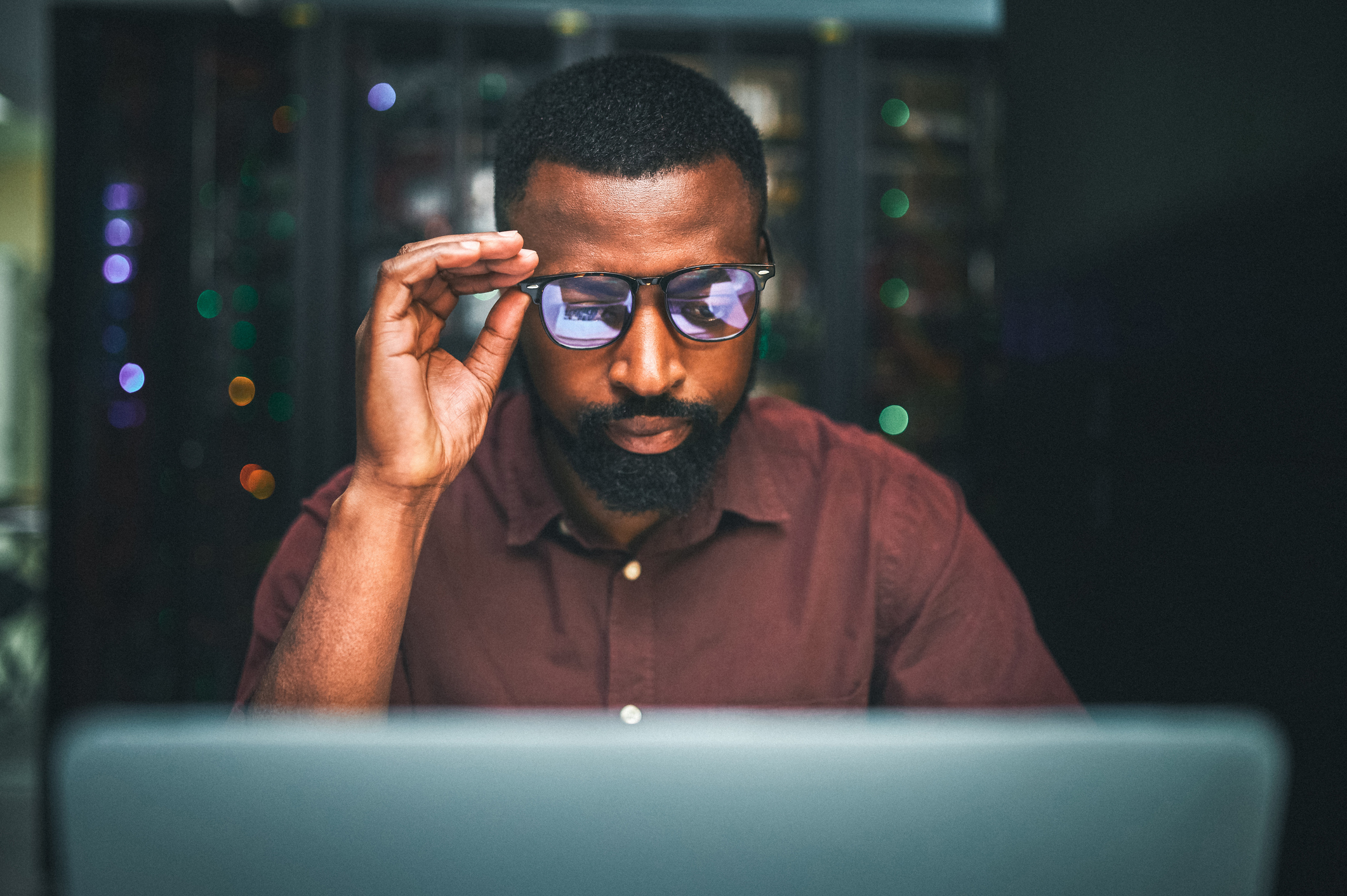 Shot of an male IT technician  in a server room and using a laptop